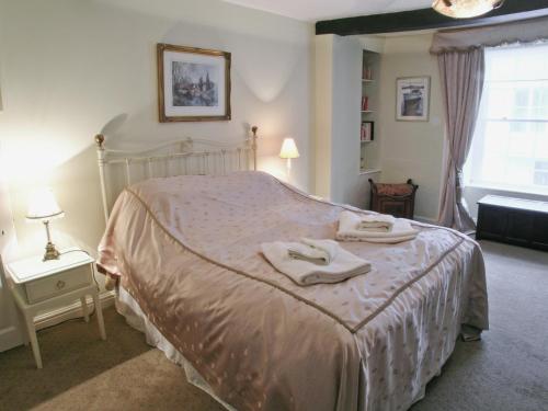 a bedroom with a bed with two towels on it at Kings House in Beaumaris