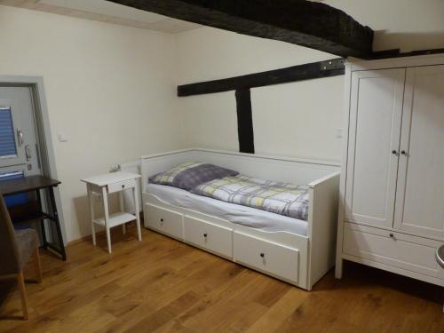 a bedroom with a bed and a table in a room at Ferienwohnung Schindewolf in Grebenstein