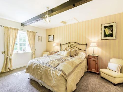a bedroom with a large bed and a chair at Coach House - E5120 in West Burton