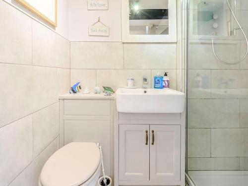a bathroom with a toilet and a sink and a shower at Coach House - E5120 in West Burton