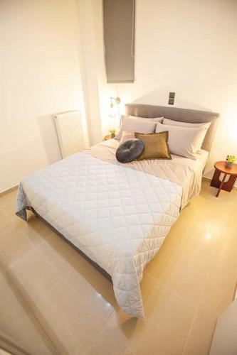 a bedroom with a large white bed with pillows at Kalafatis Downtown Apartment in Itea