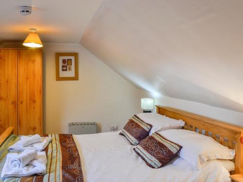a bedroom with two beds with white sheets at The Hen Hoose in Creebridge