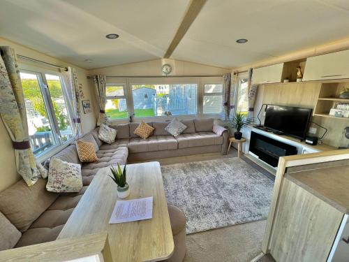 a living room with a couch and a table at Newquay Bay Resort - SummerBreeze PV54 in Porth