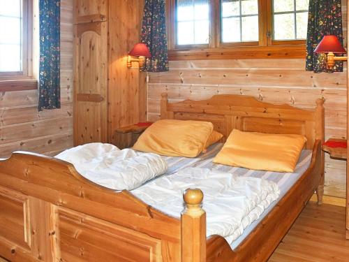 a wooden bed in a room with wooden walls and windows at Holiday home olden X in Olden