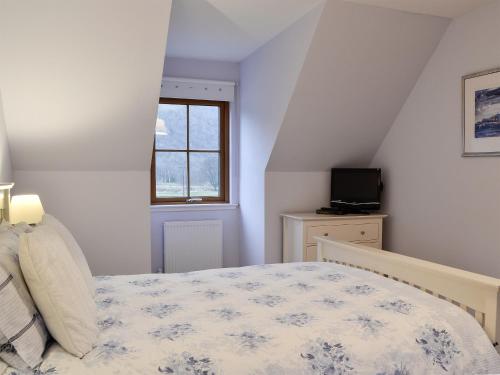 a bedroom with a bed and a window at Taigh Seonaig in Glencoe