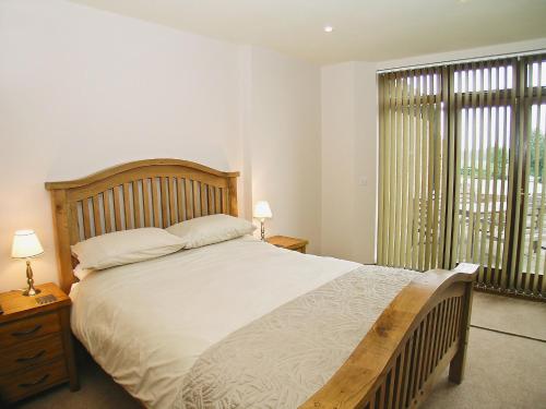 a bedroom with a large bed and a large window at Rising Sun Holiday Cottage in Aldwark