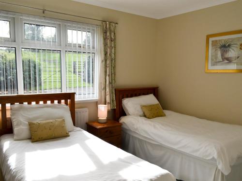 two beds in a room with a window at Bridge End Farm in Frosterley