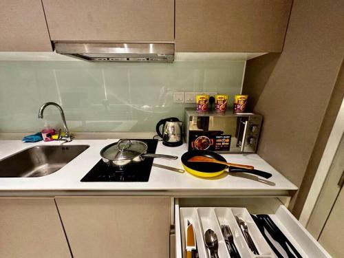 a small kitchen with a stove and a sink at Royal Suite~Tamarind 2Q Bed in Cyberjaya