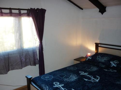 a bedroom with a bed and a window at Apartmani Andrija in Jezera