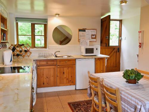 a kitchen with a table and a microwave at The Garden House in Atlow
