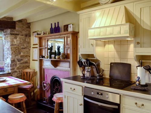 cocina con fogones y chimenea en Mullions Cottage, en Castleton