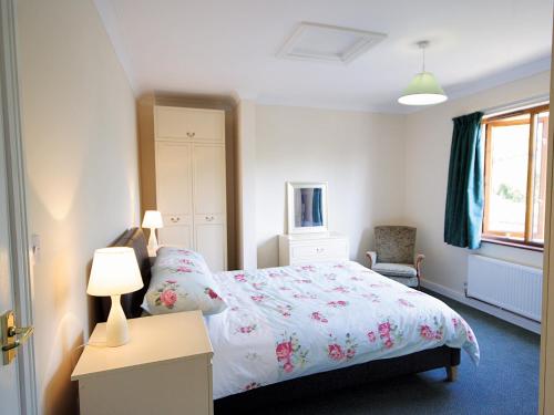 1 dormitorio con 1 cama y 1 mesa con 2 lámparas en Nautical Nook en Stalham