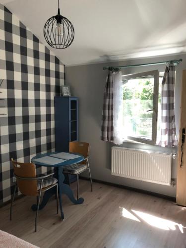 a dining room with a table and chairs and a window at Uniejów PORT pod Sosnami in Uniejow