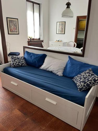 Elle comprend un grand lit avec des oreillers bleus et un miroir. dans l'établissement Accogliente appartamento a 25 minuti da milano, à Parabiago