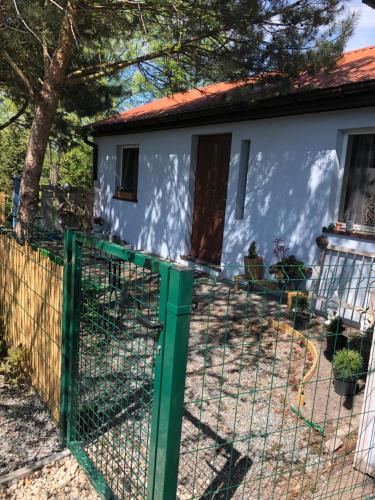 a house with a green fence in front of it at Uniejów PORT pod Sosnami in Uniejow