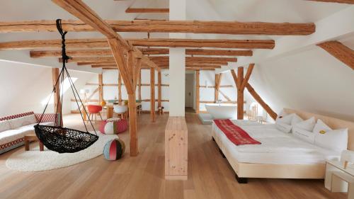 una sala de estar con una hamaca en una habitación con techos de madera. en Kavaliershaus Schloß Blücher am Finckenersee, en Fincken