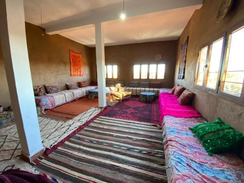 a living room with couches and a rug at jardin du desert in Mhamid