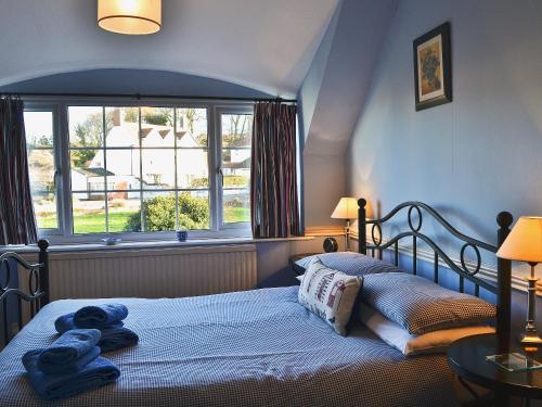 a bedroom with a bed with blue towels on it at Harbour Cottage in Winterton-on-Sea