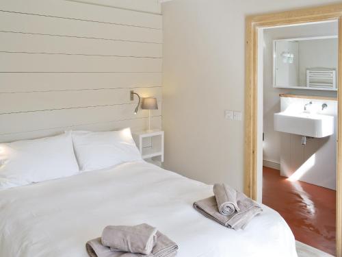 a bedroom with a white bed and a sink at Seasong in Salthouse