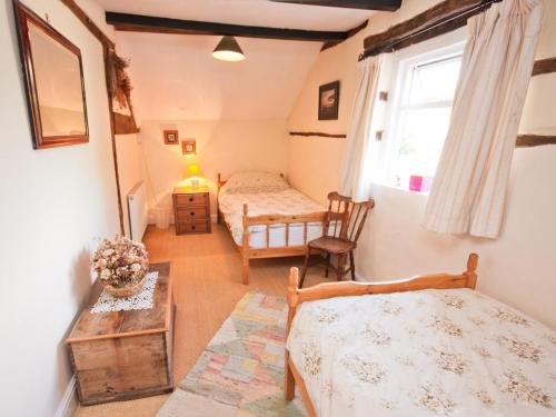 1 dormitorio con 2 camas y ventana en Rye Court Cottage, en Birtsmorton