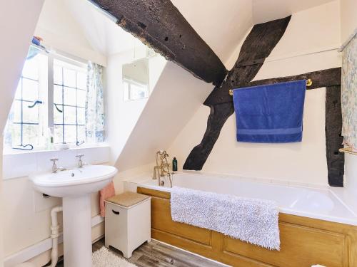 a bathroom with a sink and a bath tub at Glebe Cottage in Powick