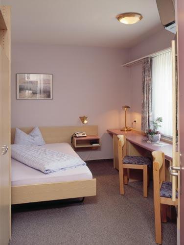 a bedroom with a bed and a desk and a desk at Hotel Sonne in Altstätten