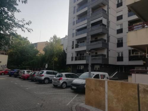 ein Parkplatz mit Autos vor einem Gebäude in der Unterkunft He-Ra apartment 6 with Free Netflix in Skopje