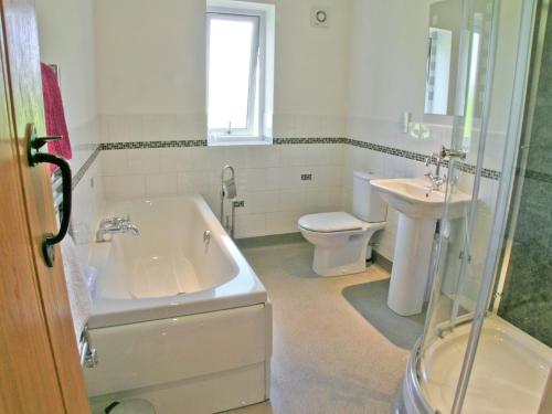 a bathroom with a tub and a toilet and a sink at Swallows Nest in Soulby