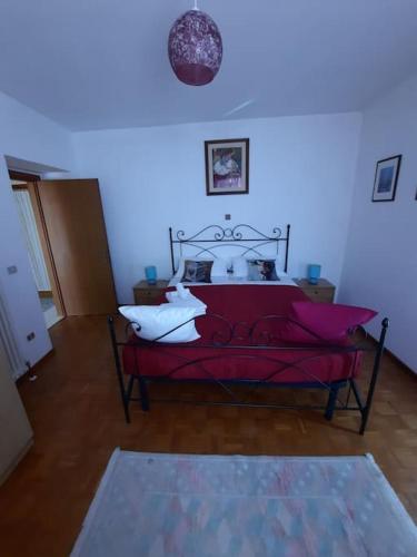 a bedroom with a red bed with white pillows at Le Pleiadi in Bieno