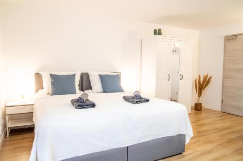 um quarto com uma grande cama branca com almofadas azuis em Gästezimmer ROSS em Hohenlinden