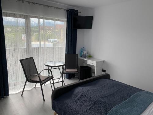 a bedroom with a bed and a table and chairs at Vila Victory in Tohanu Nou