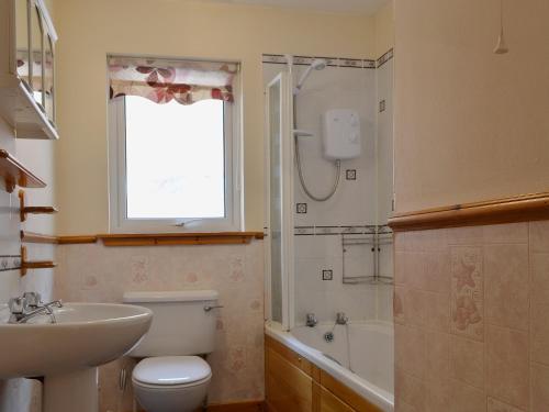 a bathroom with a toilet and a sink and a tub at Shore View in Portree