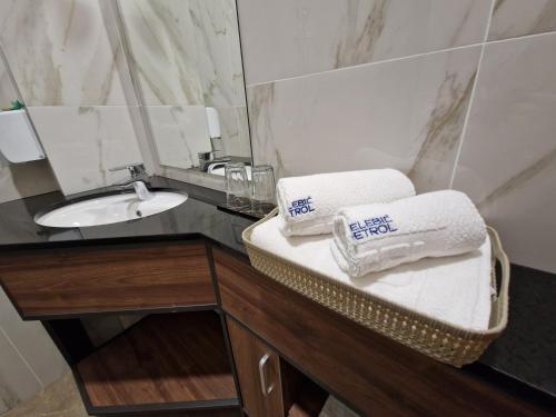 uma casa de banho com lavatório, espelho e toalhas em Motel Celebic em Podgorica