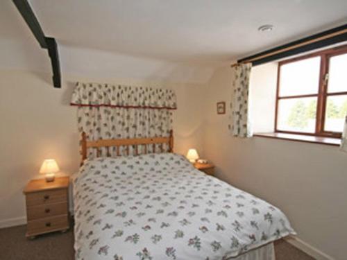 een slaapkamer met een bed en een raam bij Honey Acre Cottage - E2379 in Banwell