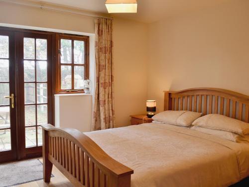 a bedroom with a large bed and a window at Jasmine Cottage - 30503 in West Firle