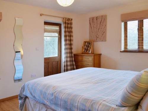 Bearsted的住宿－馬厩鄉村別墅，一间卧室配有一张床、一个梳妆台和一扇窗户。