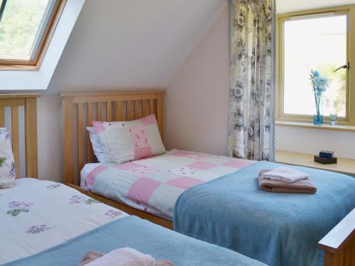 a bedroom with two beds and a window at Beer Farm in Stawley