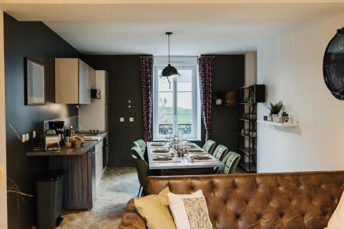 Appartements Cherbourg في شيربوغ أون كوتننتين: مطبخ وغرفة معيشة مع أريكة وطاولة