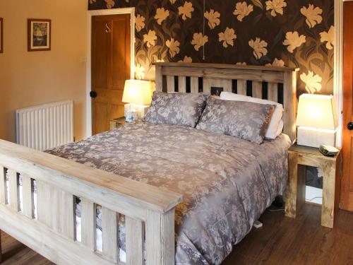 a bedroom with a large wooden bed with two lamps at Glaramara in Kendal