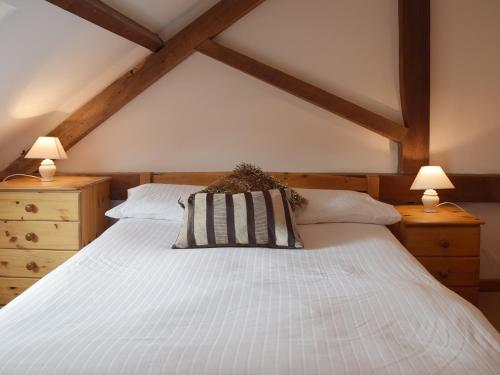 a bedroom with a large white bed with two lamps at Coriander - E4323 in Ludham