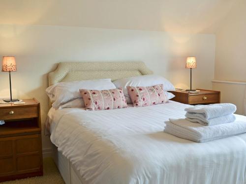 斯卡布羅的住宿－Holbeck Apartment，卧室配有白色床、粉色枕头和两盏灯。