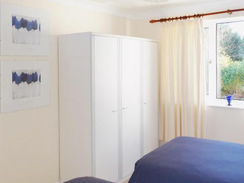 a bedroom with a white cabinet and a window at Avalon in Grainthorpe