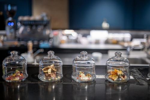 four glass domes with figurines in them on a counter at Pytloun Boutique Hotel Prague in Prague