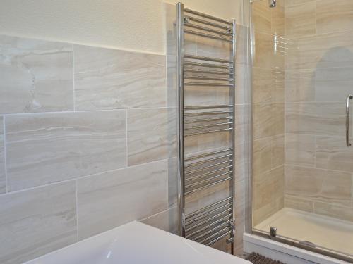 a bathroom with a shower and a white tub at Chapel View in Filey