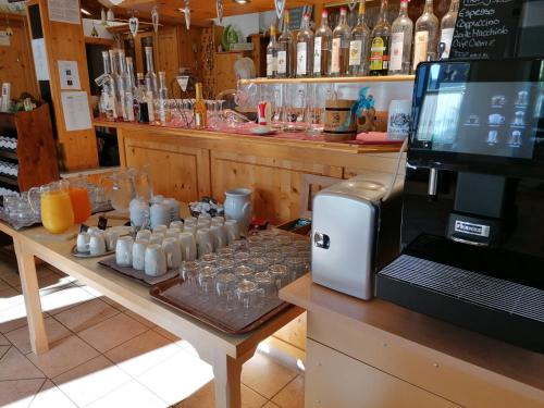 a bar with a counter with glasses and a microwave at Pension Drei Linden in Obertrubach