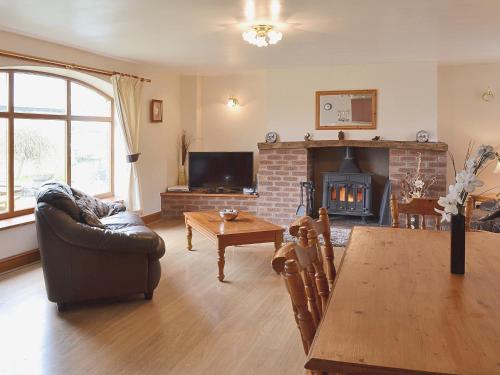 uma sala de estar com um sofá e uma lareira em The Cottage - 28645 em Alston