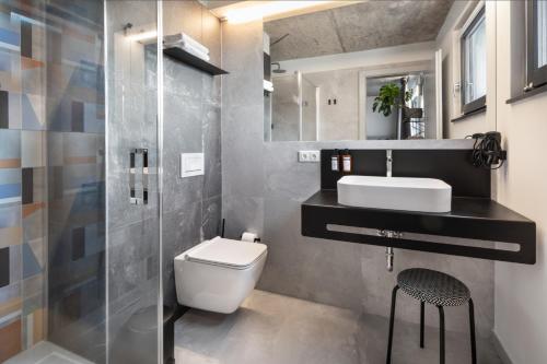 uma casa de banho com um WC, um lavatório e um chuveiro em Boutique Hotel Mezi švy em Hradec Králové