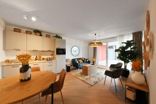 a kitchen and a living room with a table and chairs at Résidence Services CAZAM in Clermont-Ferrand
