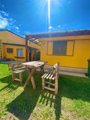 une table de pique-nique et un banc devant un bâtiment dans l'établissement Las Cabañitas, à El Calafate