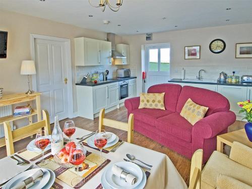 a living room with a red couch and a table at Lapwing Cottage - E5028 in Birtley